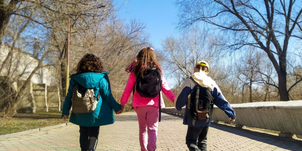 young children walking with backpacks